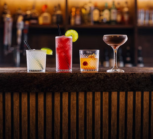 Cocktails lined up on the bar at golden hour